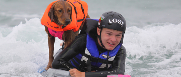 Chien fait du surf avec un enfant atteint de quadriplégie